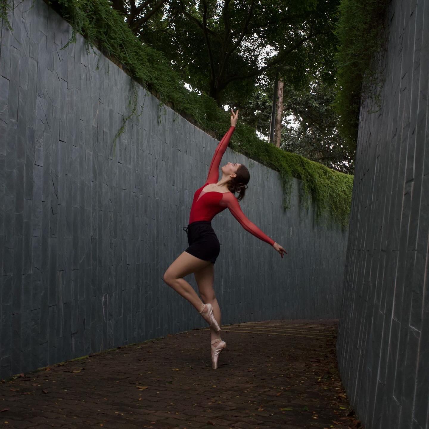 Ballet dancer en pointe in a stone corridor